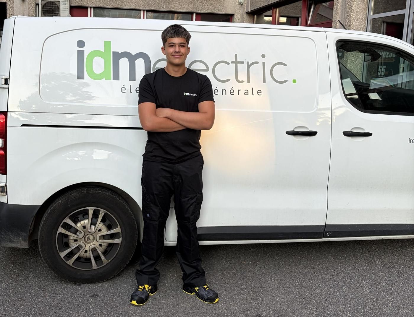Apprenti IDMElectric devant un véhicule de l'entreprise